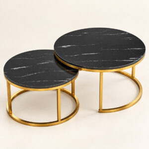 Two black marble nesting coffee tables with gold circular metal bases on a light background
